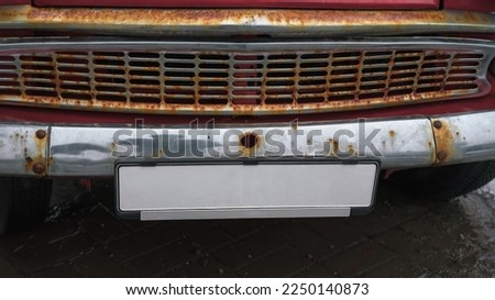 Empty numberplate fixed under rusty car grid. Old licence plate with mockup space.