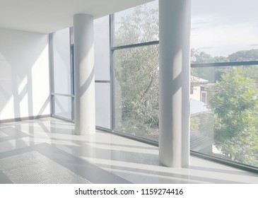 Empty office corridor with glass curtain wall and light from sunlight. Modern building interior background, high key 