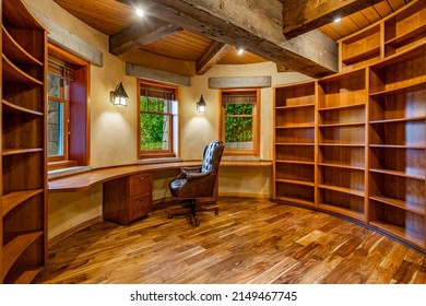 Empty Office With Heavy Wooden Beams Solid Wood Flooring Windows With Greenery View And A Single Black Office Chair