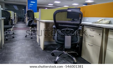 An empty office with none around and cubicles with beautiful reclining chairs arranged around during covid-19, coronavirus pandemic and social distancing time.