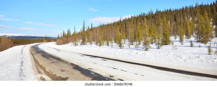 Empty Old Asphalt Road (highway) Through The Pine Forest. Snow-covered Mountains. Winter Landscape. Kola Peninsula, Polar Circle, Russia. Expedition, Work, Route, Logistics, Remote Places, Off-road