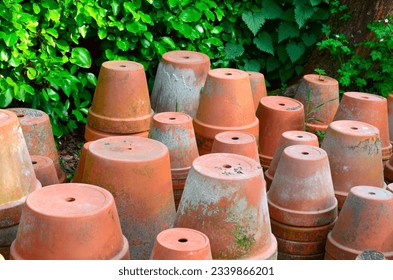 Empty old clay ceramic flower pot piles. Piles of old flower pots in a British garden. Stack of empty plant pots on the ground outside. - Powered by Shutterstock