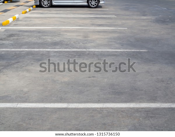 Empty old outdoor parking lot with car and\
white line on sunny day with copy\
space.