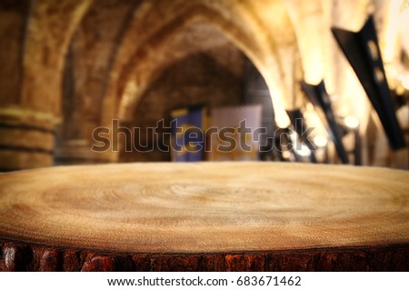 Empty old table in front of ancient knight stone tower. Useful for product display montage