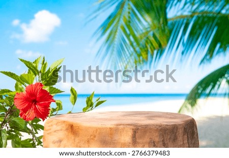 Empty old tree stump table top with beautiful red flower on blurred tropical sea and palm background for product display