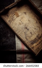 Empty Old Vintage Rustic Wooden Kitchen Tray For Food Preparation Lying On A Cloth On A Kitchen Counter, Overhead View With Vignetting