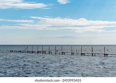 Empty old wooden pier in the sea on a sunny day. - Powered by Shutterstock