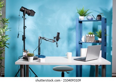 Empty online radio studio broadcasting room with professional microphone and video light used for podcast transmission. Video podcasting setup with digital mixer console and laptop computer. - Shutterstock ID 2104093109