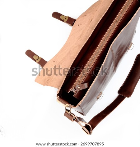 Empty and open dark brown leather bag on white background