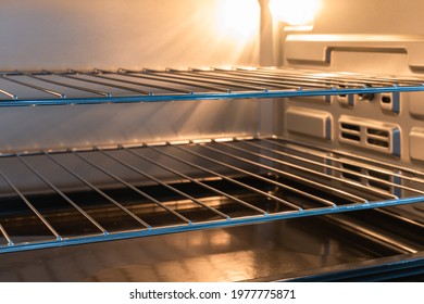 Empty Open Electric Oven With Hot Air Ventilation. New Oven. Door Is Open And Light Is On.