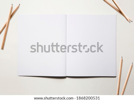 Empty open notebook with pen cil on background