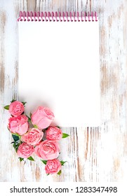 Empty open Notebook and pink roses on white wooden rustic background. copy space for design, text.  Valentine's day, love, romantic symbol concept. mock up, flat lay