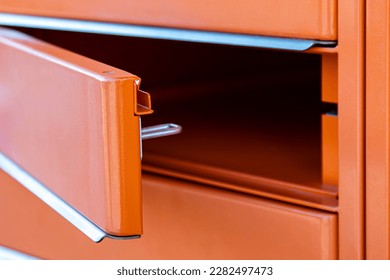 empty open orange iron box, of post parcel machine. - Shutterstock ID 2282497473