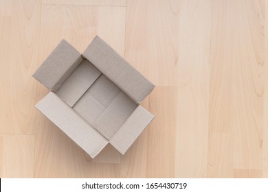 Empty open rectangular cardboard box on wood background. Shopping online object background. Shipping parcel object.