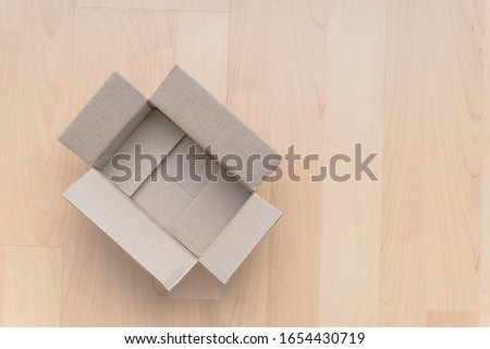 Empty open rectangular cardboard box on wood background. Shopping online object background. Shipping parcel object.