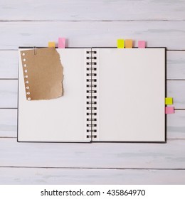 An Empty, Open Scrap Book With Page Markers On A Wooden Desk Top Background