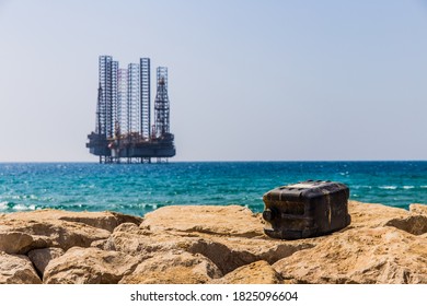 Empty Opened Gas Can In Front Of Oil Tower On The Sea