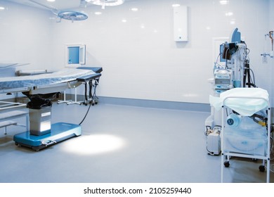 Empty Operating Room In A Hospital. Surgical Equipment With Operating Table. Medical Device For Emergency Patient In Blue Tone Style. Blank Emergency Surgery Room. Clinic Interior For Background.