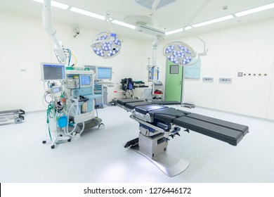 Empty Operating Room With Surgical Lamp And Anesthesiology Machine. The Black Table On The Middle Where The Doctor Do Surgery. Surgeon And Scrub Nurse Safe The Patient Life Here. Medical Concept