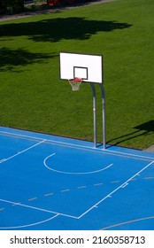 Empty Outdoor Basketball Court With Blue Floor And Basketball Basket At Park At City Of Basel On A Sunny Spring Day. Photo Taken May 11th, 2022, Basel, Switzerland.