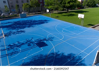 Empty Outdoor Basketball Court With Blue Floor And Basketball Basket At Park At City Of Basel On A Sunny Spring Day. Photo Taken May 11th, 2022, Basel, Switzerland.