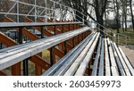 Empty outdoor bleachers in a park, preparation for sports events, community gathering space, fall atmosphere