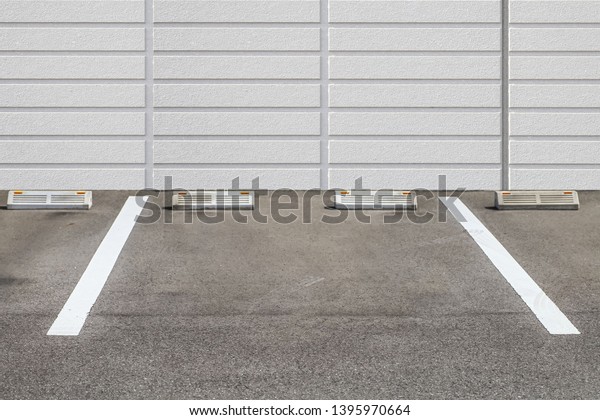 Empty\
Outdoor car parking space and stone block\
wall