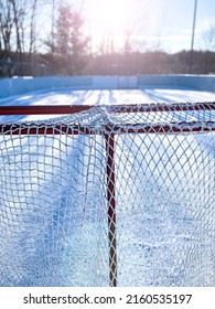 Empty Outdoor Ice Rink With Hockey Net In Winter.