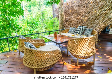 empty outdoor patio table and chair with cushions in cafe restaurant
