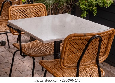 Empty Outdoor Restaurant Table with Wicker Chairs and Copy Space