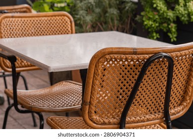 Empty Outdoor Restaurant Table with Wicker Chairs and Copy Space