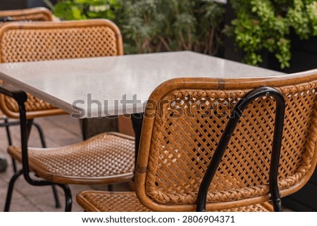 Empty Outdoor Restaurant Table with Wicker Chairs and Copy Space
