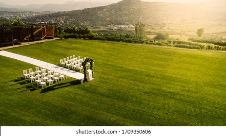 Empty Outdoor Wedding Reception Venue Set Up For The Ceremony With Chairs And Flower Arch At A Golf Club Course.Canceled Wedding.Postponed,delayed Nuptials Celebration.Newlyweds Late For Ceremony