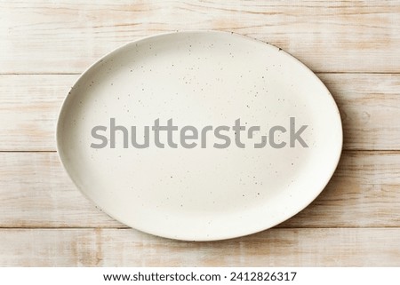 An empty oval dish on a wooden background. Top view. Copy space.