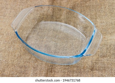 Empty Oval Glass Casserole Pan On A Surface Covered With Burlap
