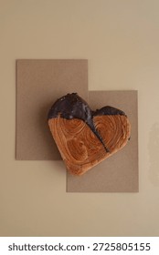 Empty paper note template sample mock up blank for wishes greeting holiday card Heartshaped pastry croissant treat topped with colorful frosting galore. Food experimentation viral dessert baking trend