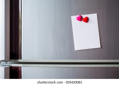 Empty paper sheet on refrigerator door. Note paper with magnetic heart. Valentine send text love message.
					