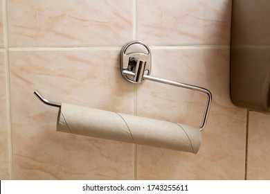 Empty Paper Towel Tube Hangs On The Toilet Wall