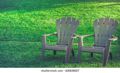 An Empty Park And Adirondack Chairs In Summer Time With Copy Space. Image For Advertise Outdoor Summer In Nostalgic Concept