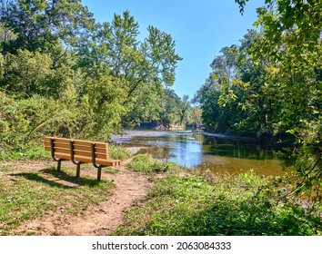 Empty Park Bench Overlooking A Lake,pond Called Neshaminy Creek In Tyler State Park In Bucks County,Pennsylvania USA.