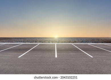 Empty parking lot against arid area and beautiful sunset sky.