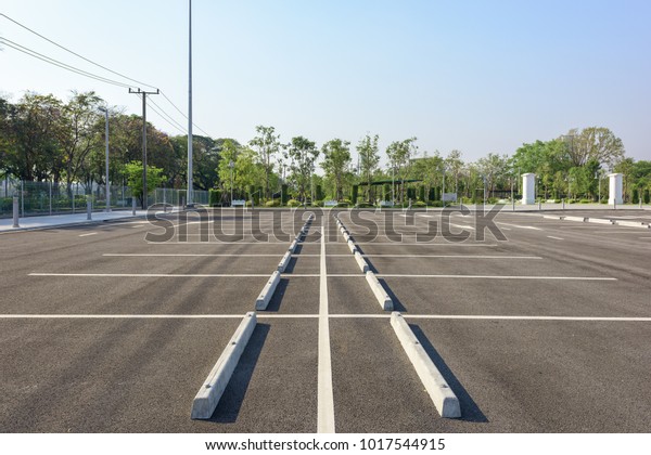 Empty parking\
lot at city center with blue sky\
