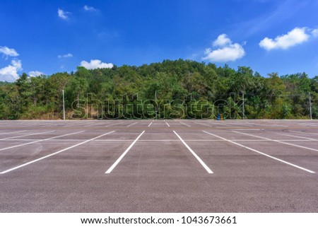 Empty parking lot with forest and beautiful blue sky.