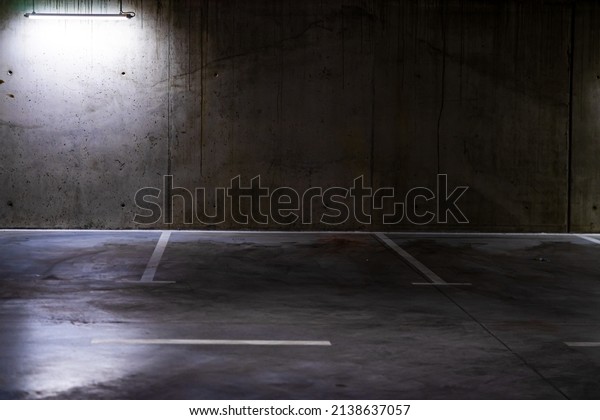 Empty parking lot with overhead dim light,\
underground parking\
garage.