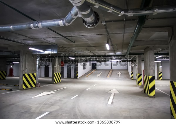 Empty parking place in a residential\
building. Covered underground parking for cars\
