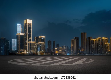 empty parking space in downtown with illuminated modern cityscape and buildings at night. - Shutterstock ID 1751398424