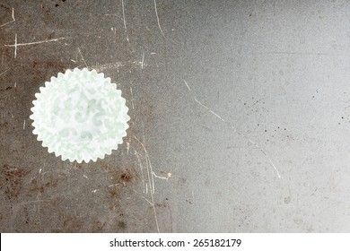 Empty Patterned Cupcake Liner On Old Baking Sheet, Horizontal Top View. Vignetted.