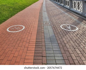 Empty Paving Walkway Around City Lake Embankment With Separate Bike Lane And Pedestrian Way, Marked With Signs. With No People, Safe Urban Environment Background.