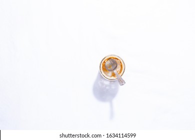 Empty Peanut Butter Jar With Spoon Inside On White Table Background With Copy Space And Shadow.Horizontal Orientation. Top View, Flat Lay