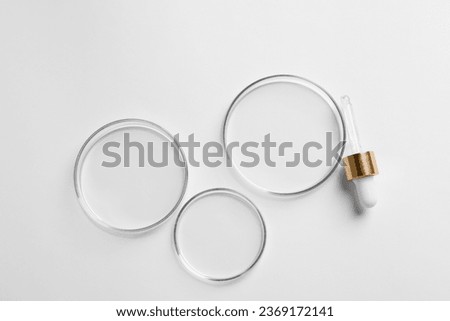 Empty Petri dishes and pipette on white background, flat lay